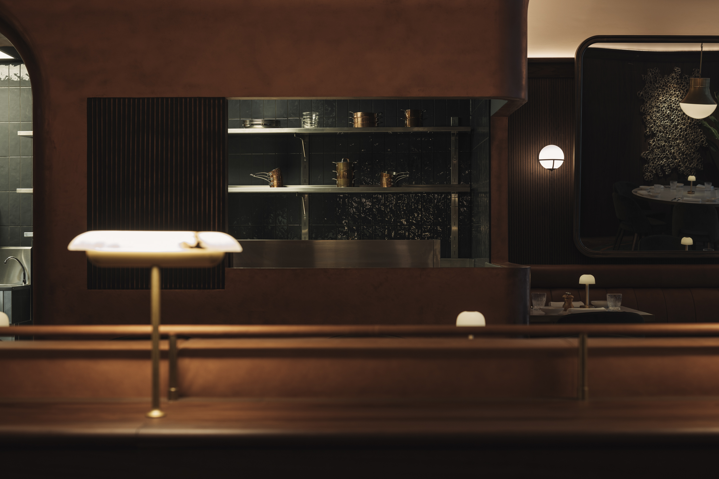 A view behind the bar at Le Petit Bon Bon, featuring soft lighting and wood panelling.